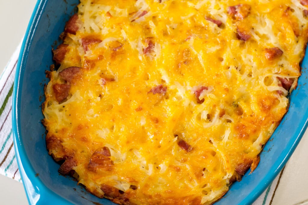 Overhead view of half of the Smoked Sausage Hash Brown Casserole in a casserole dish ready to be served.