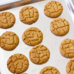 Feature image of several baked cookies still on the cookie sheet.
