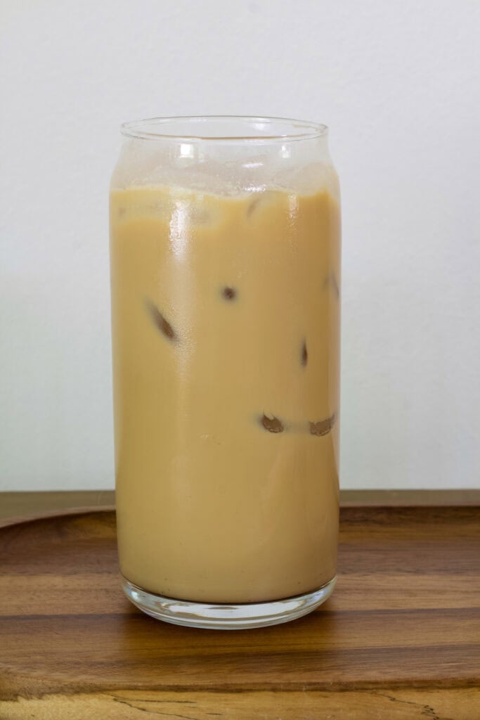 One tall glass filled with one serving of Dunkin French Vanilla Swirl Iced Coffee.