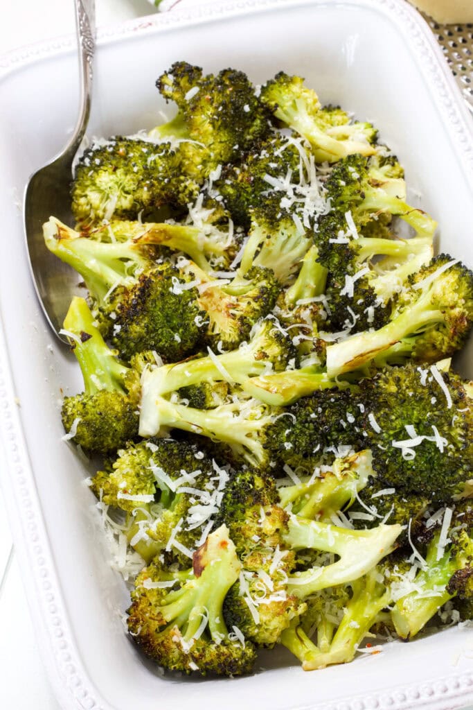 A serving dish filled with Easy Italian Roasted Broccoli topped with parmesan cheese.