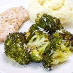Feature image of one serving of broccoli on a dinner plate with a pork chop and mashed potatoes.