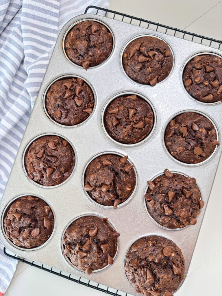 A twelve cup muffin pan with the baked Chocolate Chocolate Chip Banana Oatmeal Muffins in it.