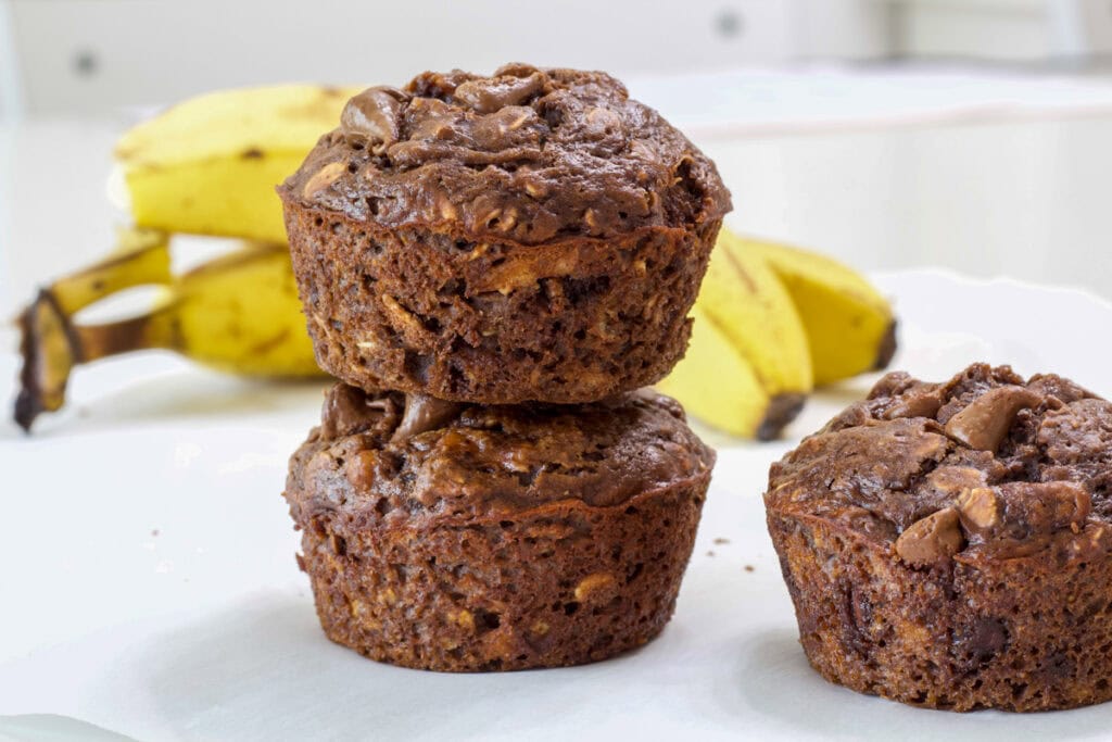 Three muffins and two bananas in the background.