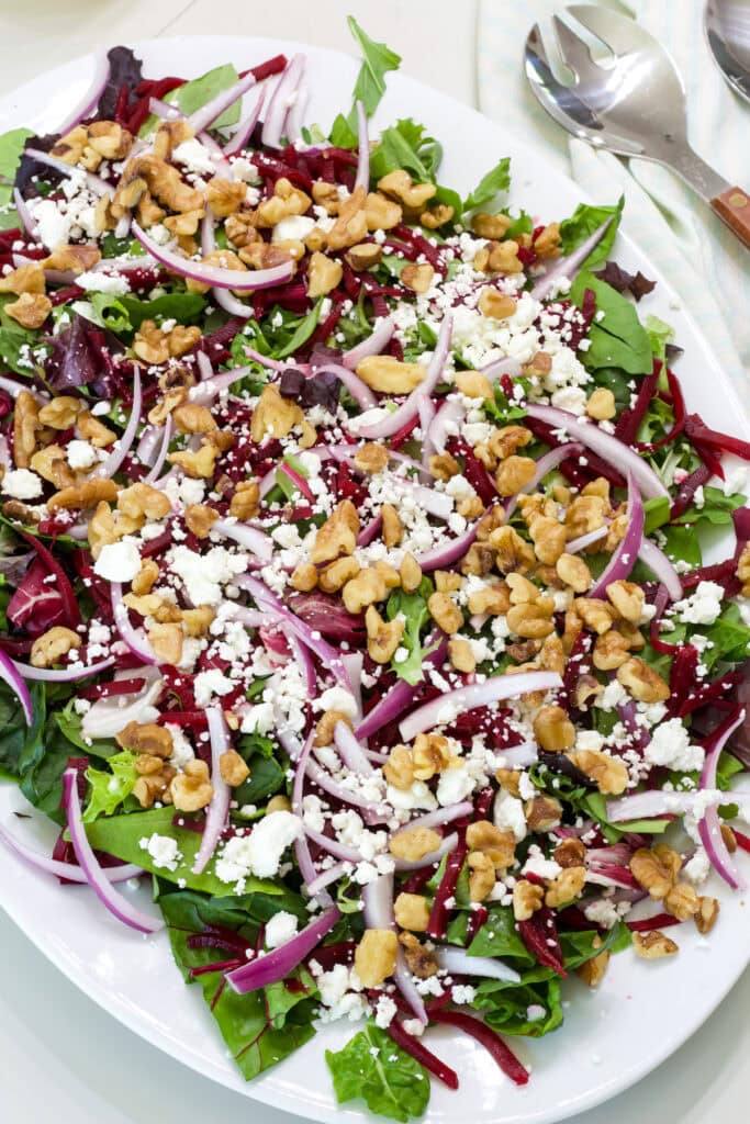 The entire Green Salad with Beets and Goat Cheese on a large white platter.