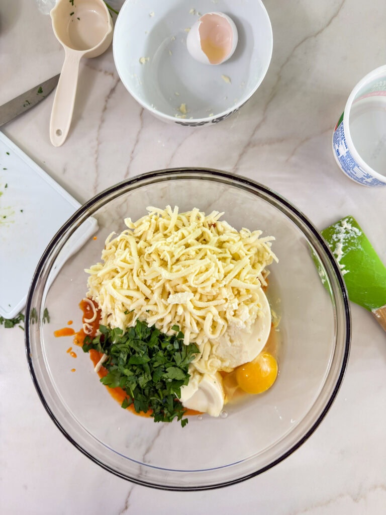 The sauce, parsley, egg and cheeses in a bowl before being mixed up.