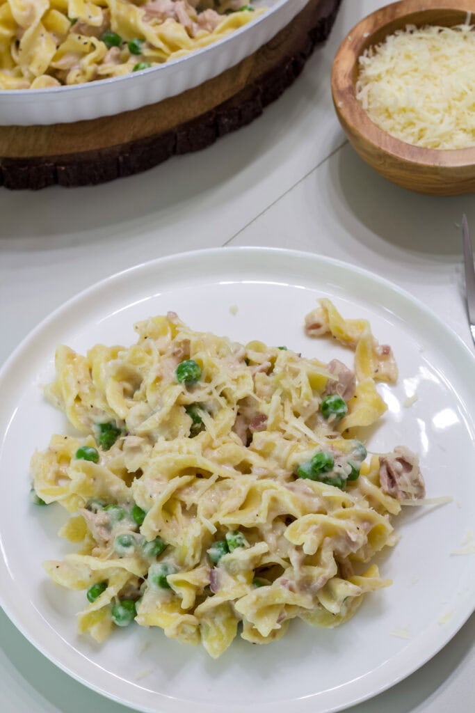 Overhead shot of one serving of Pasta with Tuna and Peas on a white plate.
