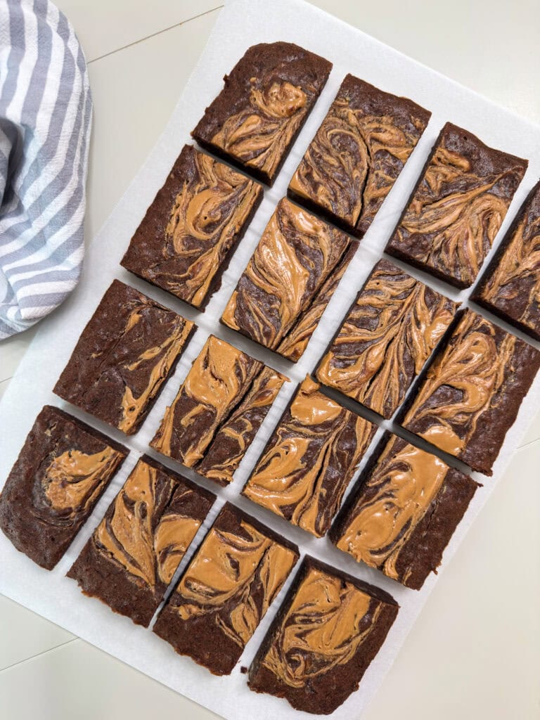 The cut Peanut Butter Chocolate Banana Brownies on a piece of white parchment paper.