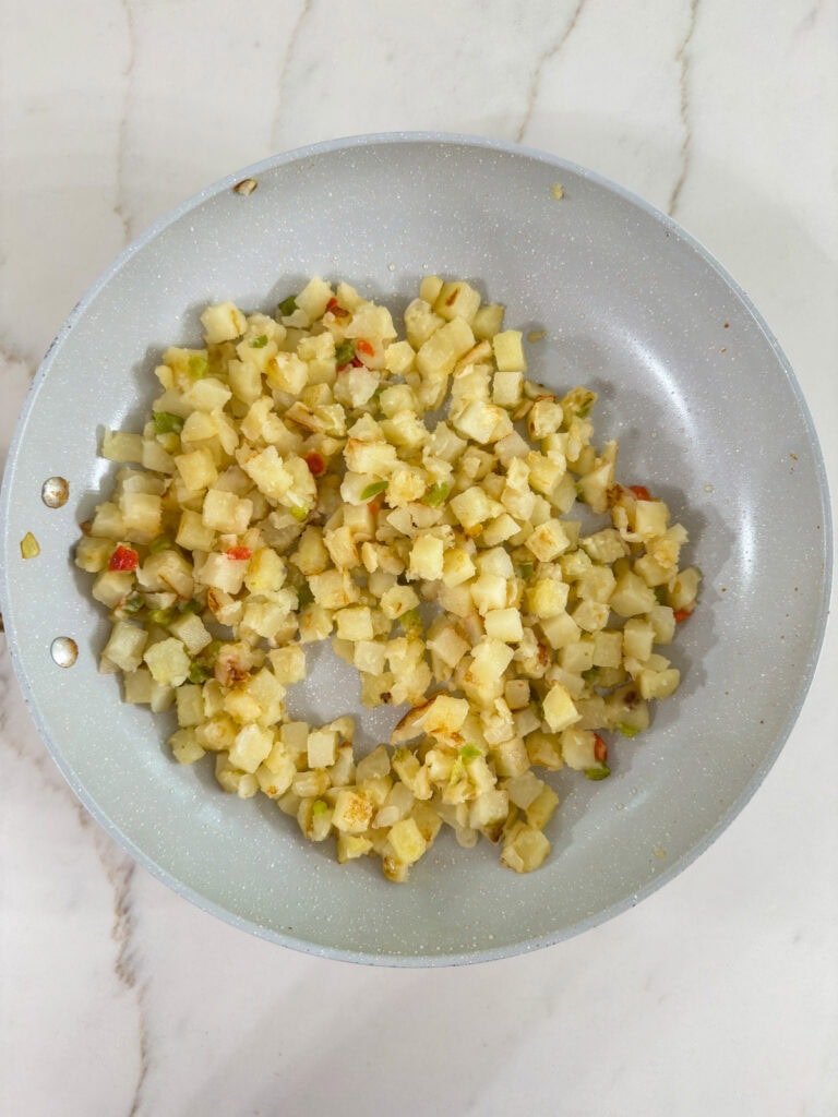 The browned potatoes in a skillet.