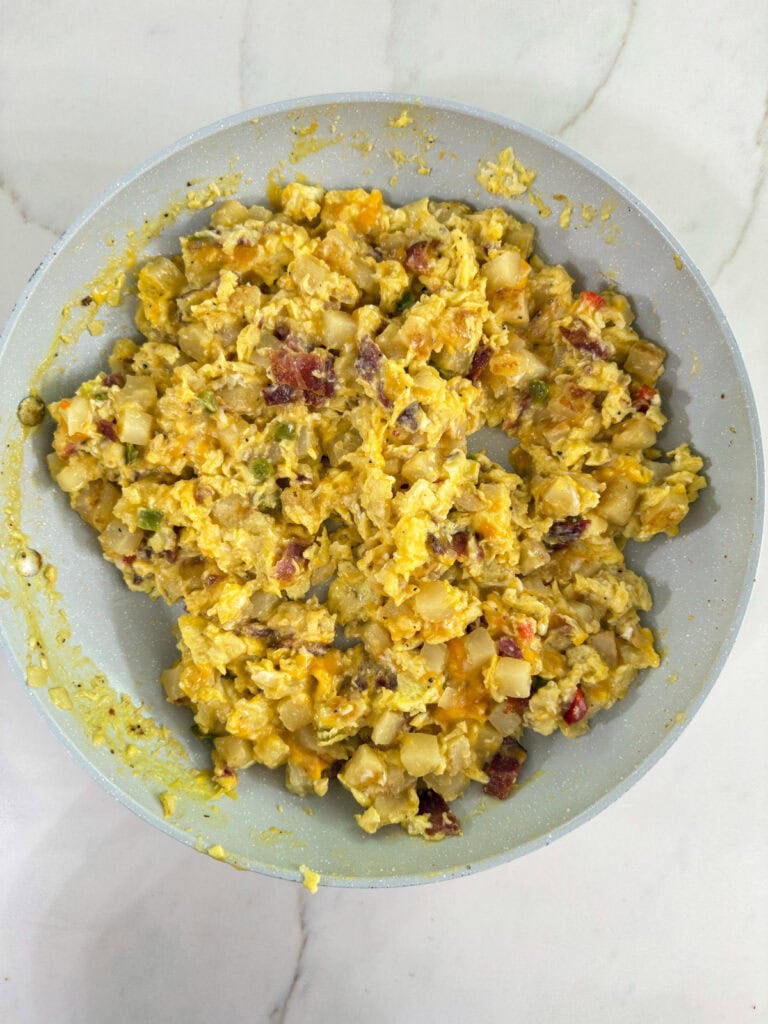 The potatoes, eggs, and bacon mixed together in the skillet after it's been cooked.