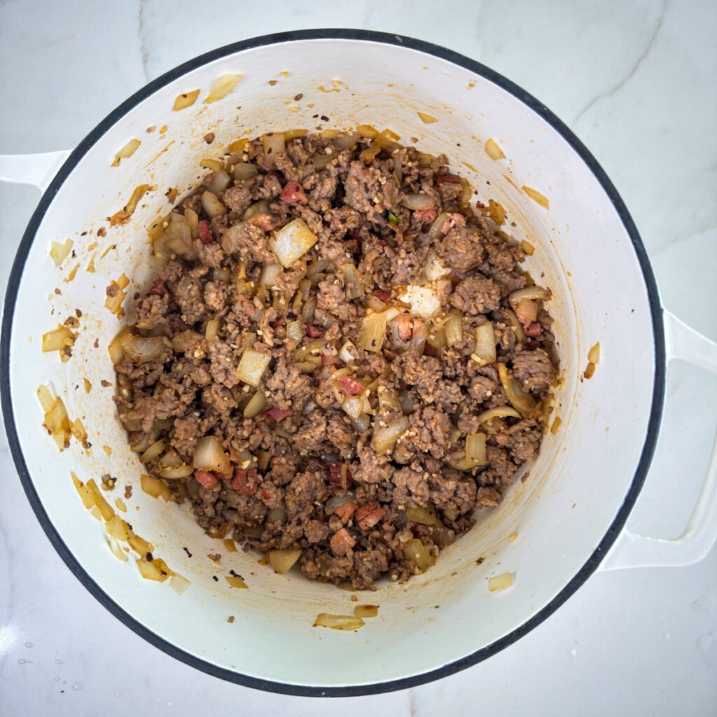 The Italian sausage, onion and garlic added to the pot of pancetta and then browned.