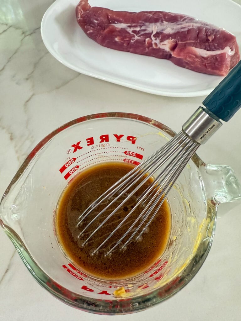 All of the ingredients for the pork marinade in a measuring cup.