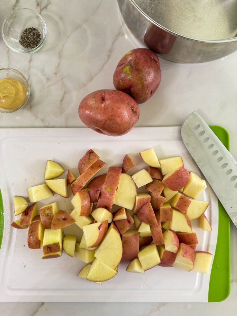 A few diced red potatoes on a cutting board.