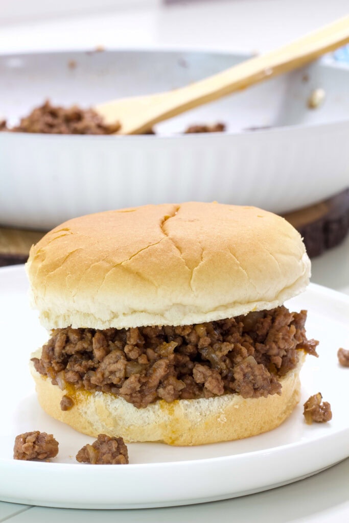 One loose meat sandwich on a white plate.
