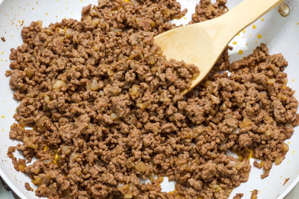 The seasoned loose meat in a skillet.