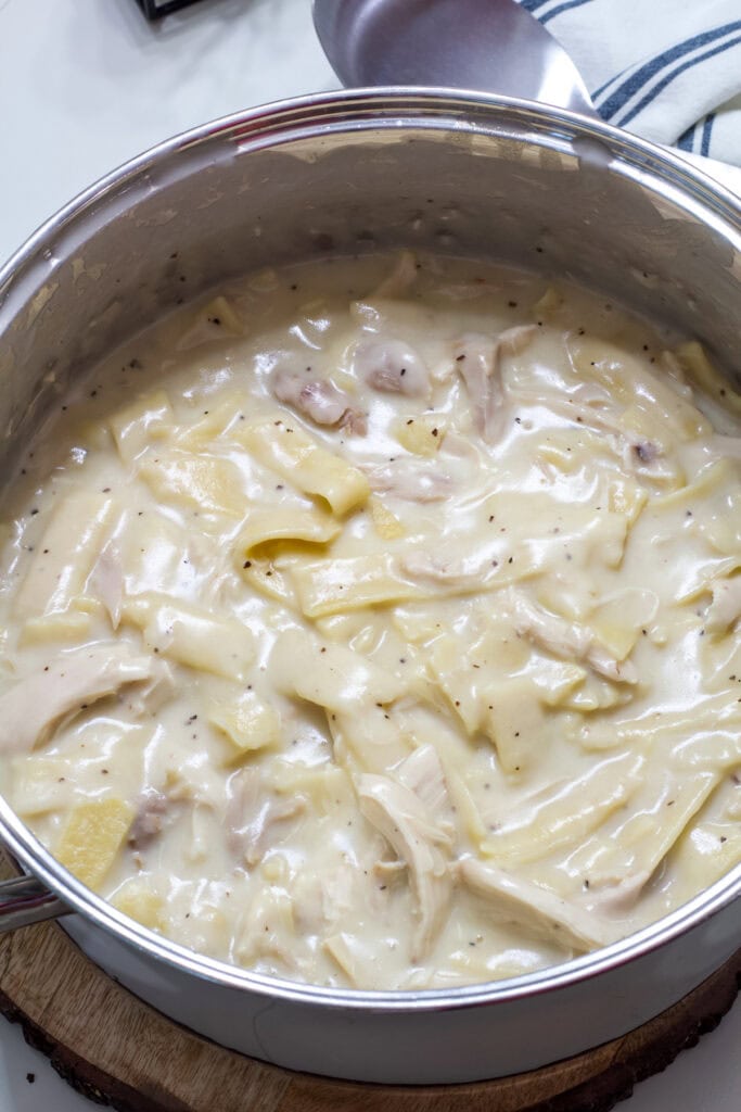 A dutch oven with the finished Old Fashioned Chicken and Noodles in it.