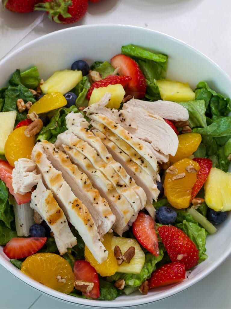 The finished salad with sliced chicken on top.