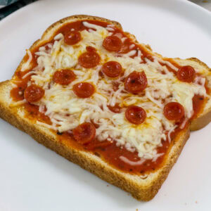 One single slice of pepperoni Sourdough Pizza Bread on a white plate.