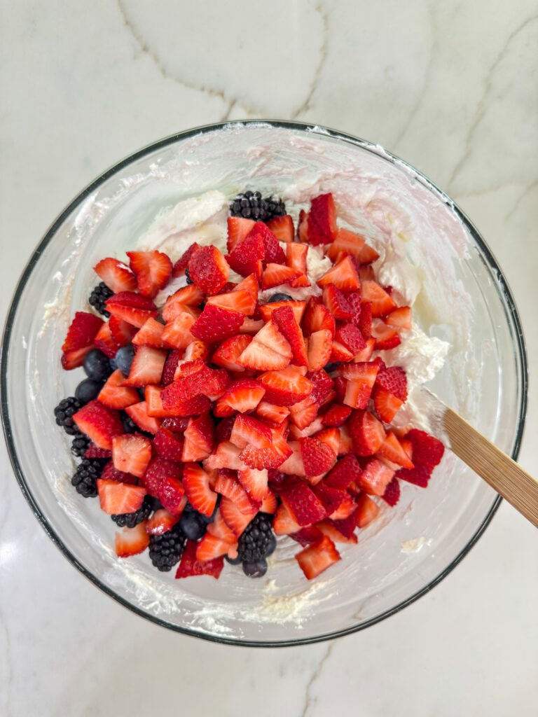 The chopped fresh berries added to the creamy cheesecake mixture.