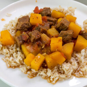 Feature image of a close up of a serving of tagine on a white plate.