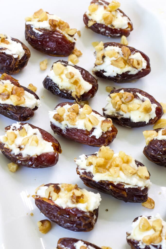 Several Goat Cheese Stuffed Dates on a white serving platter.