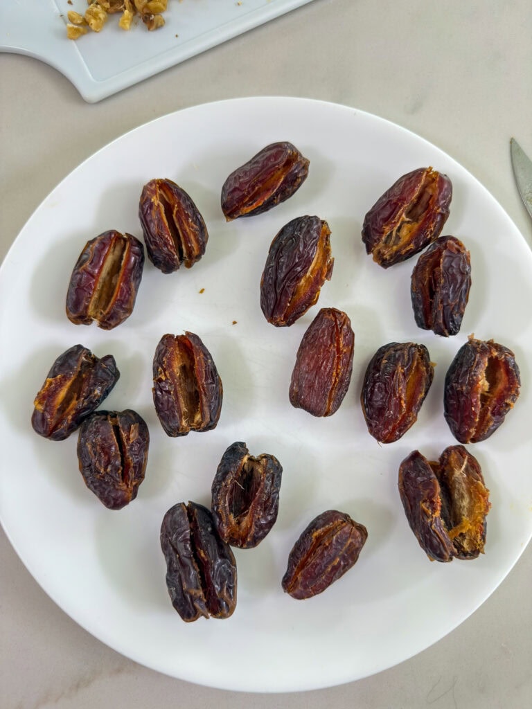 The dates on a plate after they've been sliced so they can be stuffed.