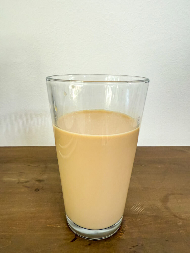 Homemade white chocolate mocha sauce has been added to the glass with coffee and milk.