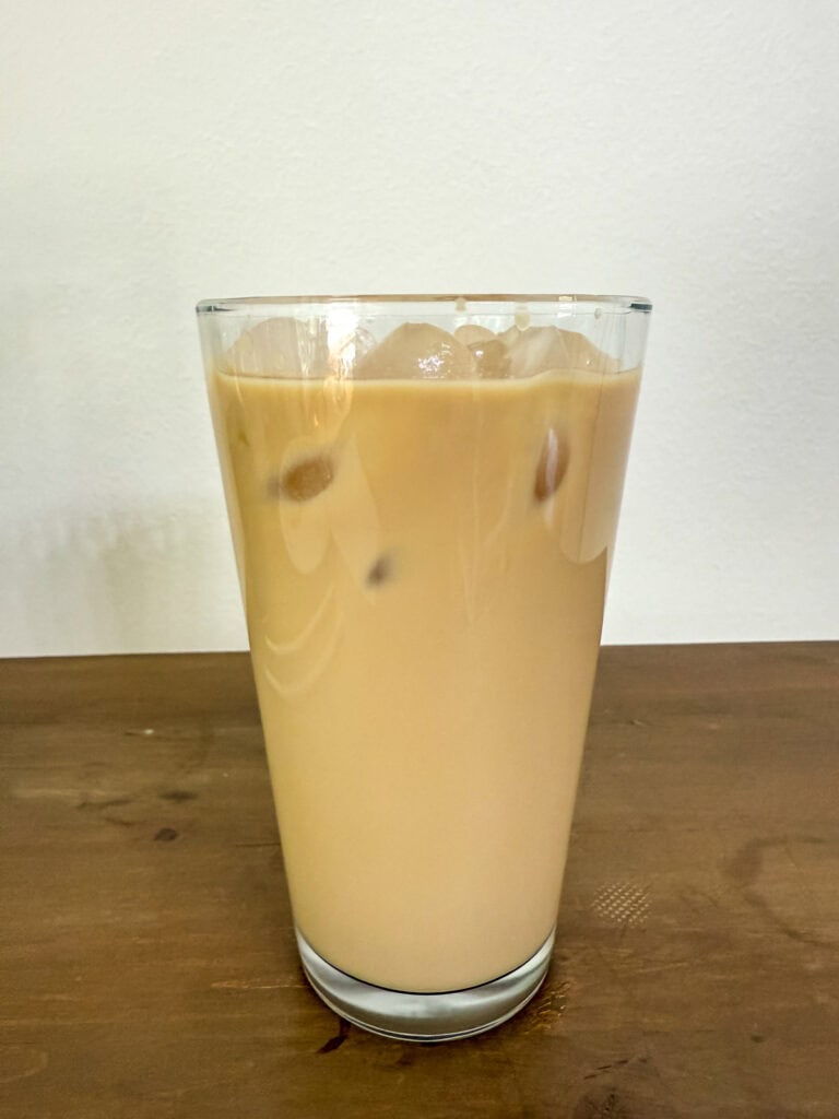 Ice has been added to the glass with coffee, milk and white chocolate mocha sauce.