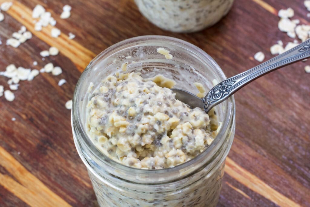 Close up overhead shot of the overnight oats in the mason jar with a spoon in it.