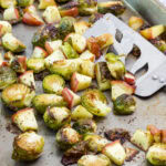 Feature image of the Oven Roasted Brussels Sprouts with Apples on a sheet pan after they came out of the oven.