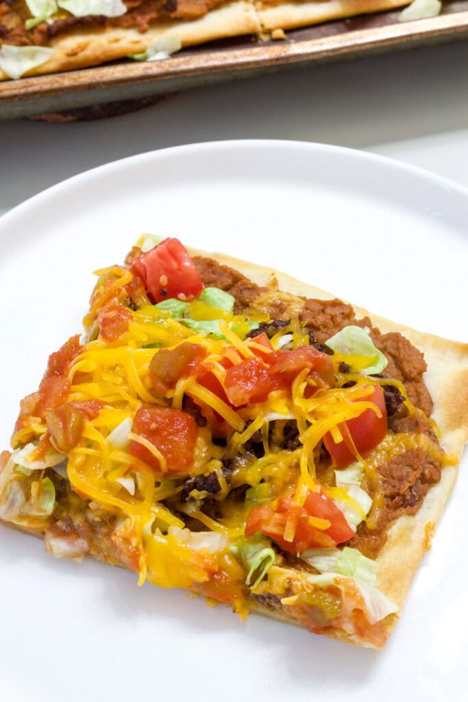 One piece of Super Easy Taco Pizza on a white plate.