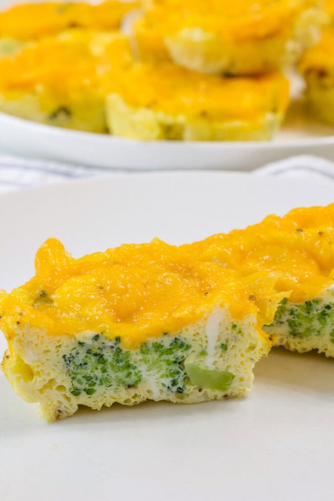 Close up of one Broccoli Cheddar Egg Bites cut open so the middle is visible.