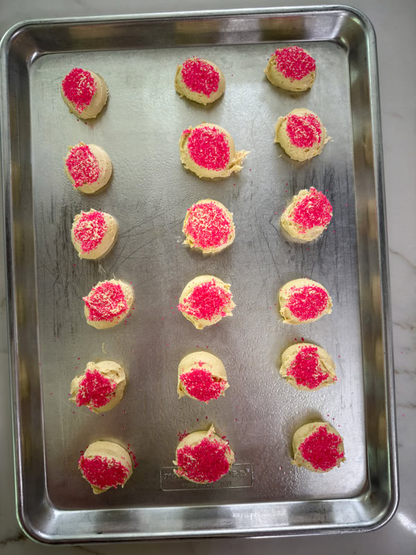The cookie dough balls flattened and topped with sanding sugar ready to go into the oven.