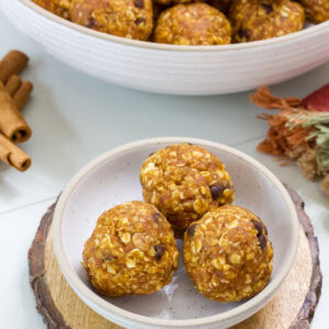 Feature image of three pumpkin energy balls in a small bowl.