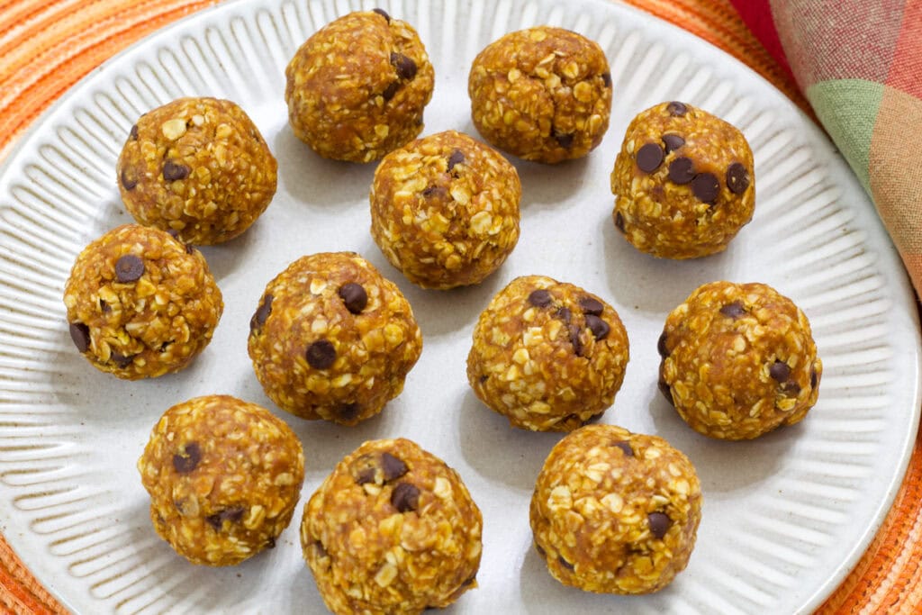 A dozen Pumpkin Energy Balls (vegan, gluten-free) on a natural colored stone plate.