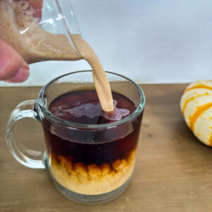 Feature image of the Pumpkin Spice Creamer being added to a cup of coffee.