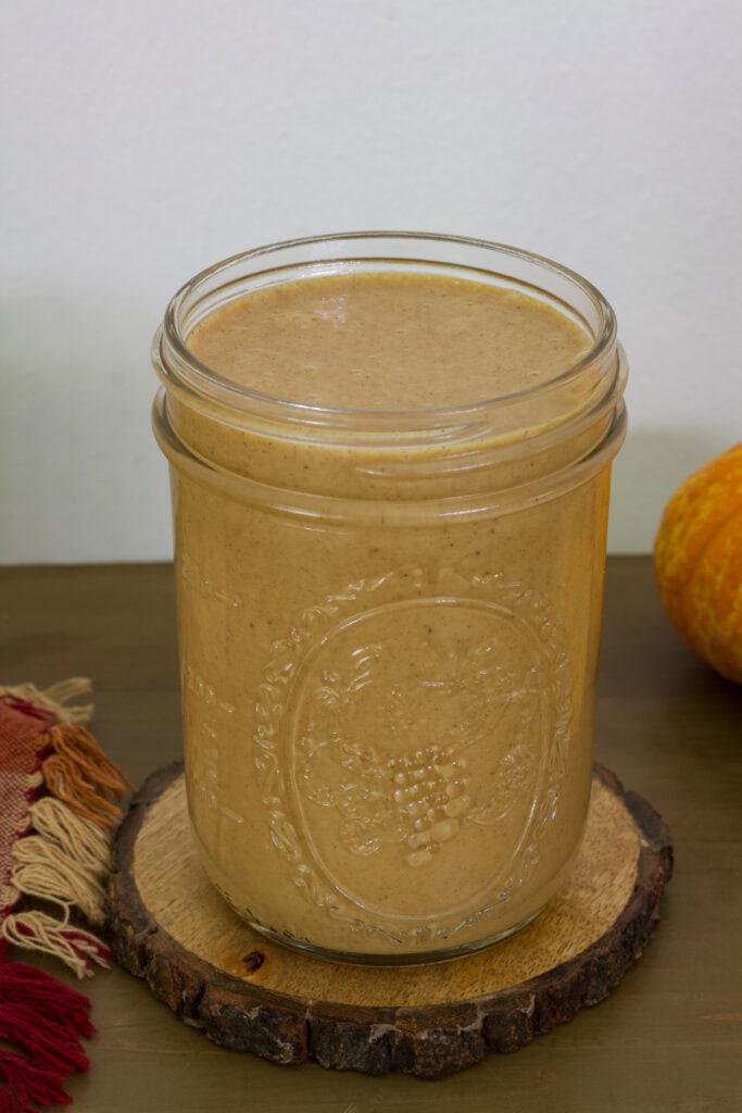 A mason jar filled with homemade Starbucks Pumpkin Sauce.