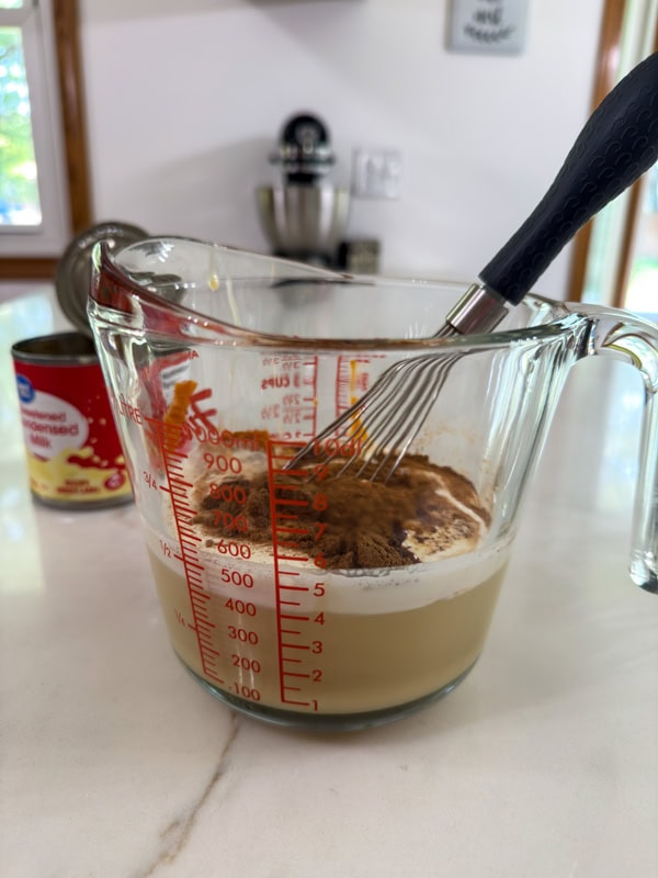 A 4-cup measuring cup with all of the ingredients in it before being whisked together.