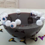 Feature image of a side view of the punch bowl filled with dark purple Halloween punch.