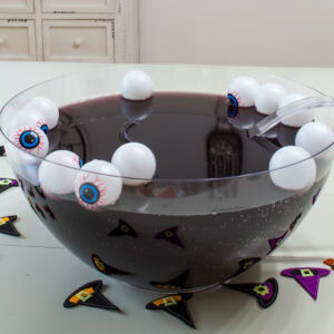 Feature image of a side view of the punch bowl filled with dark purple Halloween punch.