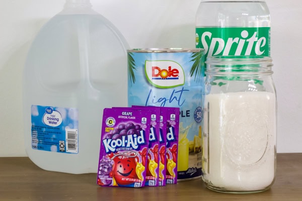The water, pineapple juice, Sprite, Kool-Aid packets and sugar needed to make the Witches Brew Halloween Punch recipe.