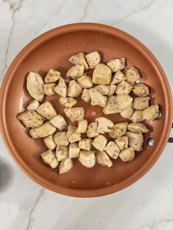 The chicken chunks in the skillet cooked and ready for the barbecue sauce to be added.