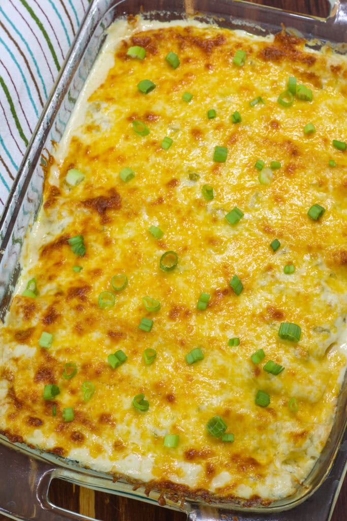 The finished Chicken Enchiladas with White Sauce in a glass casserole dish.
