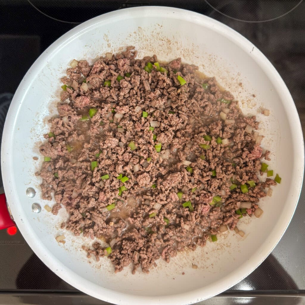 The browned ground beef in a skillet.