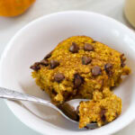 A serving of baked oats with one bite in a silver spoon.