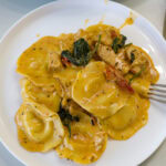 Overhead shot of one serving of Tuscan Ravioli with Chicken on a plate.