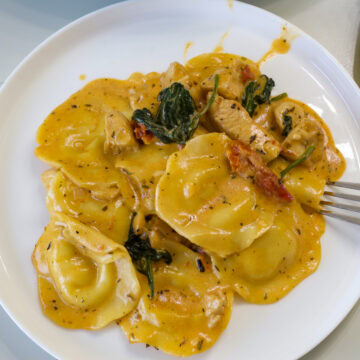 Overhead shot of one serving of Tuscan Ravioli with Chicken on a plate.