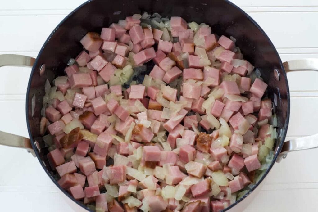 The ham and onion in a dutch oven after they've been cooked.