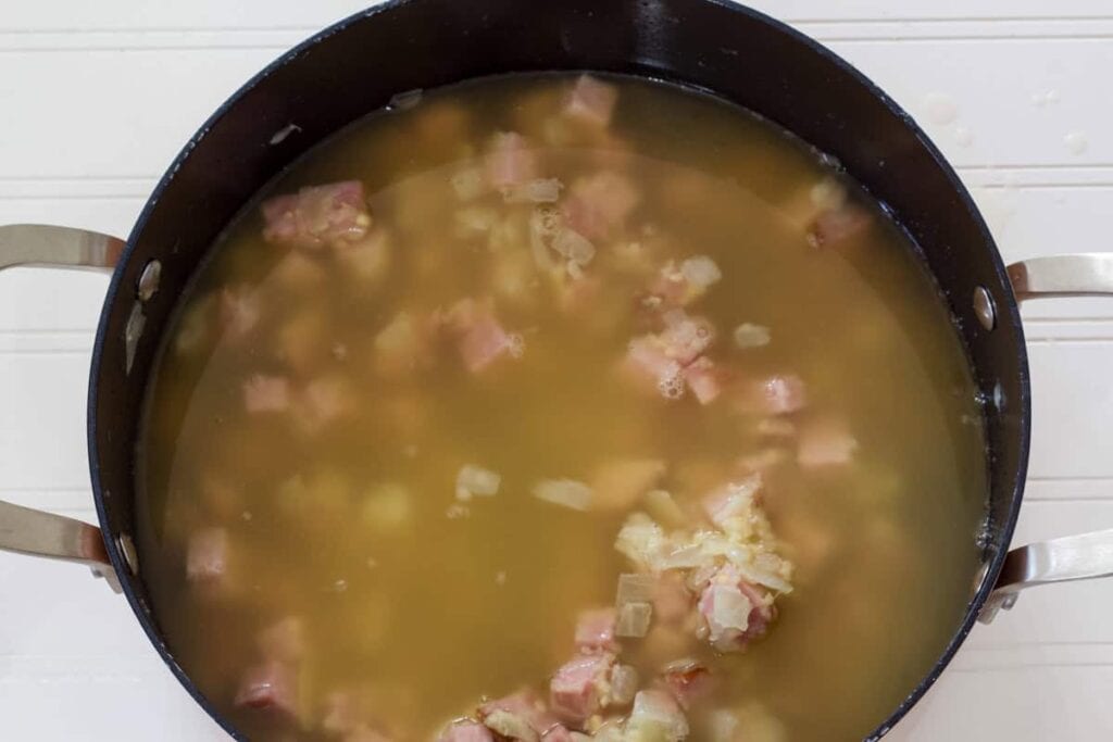 The pot with the ham, onion and chicken broth added.