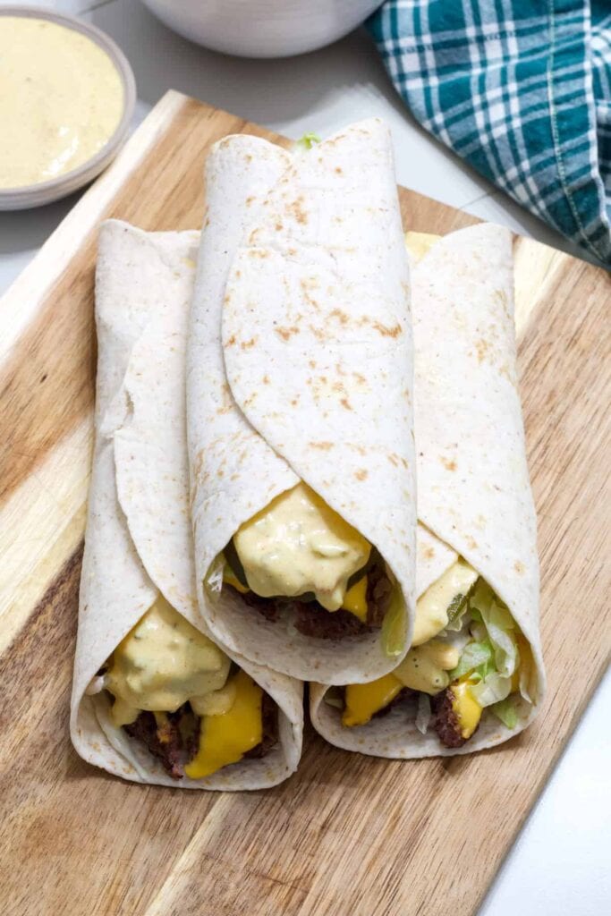 Overhead shot of three Big Mac Wraps on wooden cutting board.