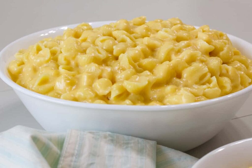 Side view of a white serving bowl filled with Mac and Cheese with Shells.